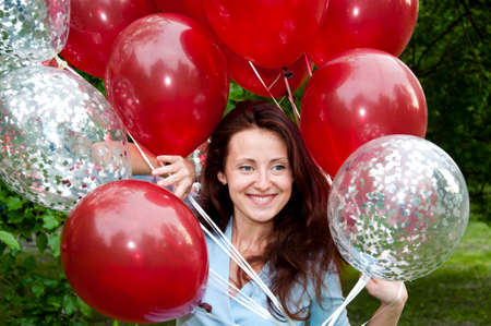Always young at heart. happy woman with party birthday baloons outdoor in summer.の写真素材