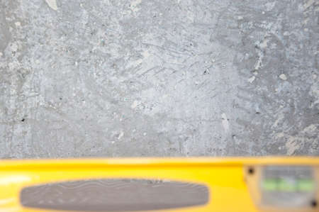 blurred waterpas on cemet wall background. copy space. Construction tool instrument. repair and...
