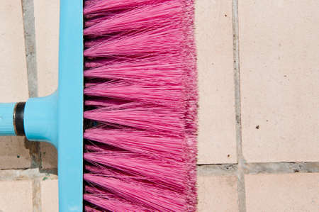 fetlock on tile wall background. brush for repair and construction. building concept. work tool and equipment. working with broom. painting and priming wall paint. Pink cleaning equipment. copy space.の写真素材