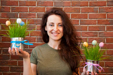 happy woman with easter egg decoration. potted plant.