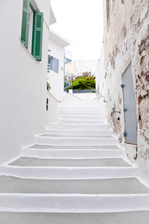 Narrow medieval street with white stone steps in old mediterranean town.の写真素材