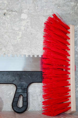 Plastering spatula and brush for renovating on concrete wall cement background, redecoration.の写真素材