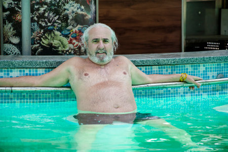 senior man relax in summer pool on summertime vacation.の写真素材