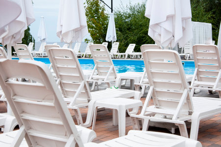 summer beach holiday. summertime lifestyle. outdoor resort at poolside. pool sunbed and sun lounger....