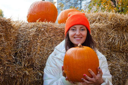 autumn style. happy halloween holiday. woman in autumn hay outdoor. halloween pumpkin. woman with halloween pumpkin at hay in autumn. trick or treat. halloween girl. woman in the hay. copyspace.の写真素材