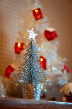 Christmas tree decoration. Decoration for New Year holiday celebration. Happy New Year. Christmas Tree Background. Beautiful Christmas gift near fir tree in room. Festive Christmas scene.の写真素材