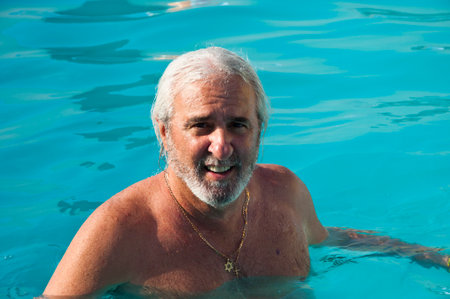 Senior man swimming in pool. Summer vacation and retirement. Senior man at spa resort in summer.の写真素材