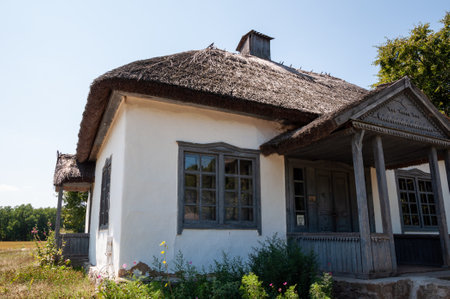 Authentic Ukrainian house in countryside. Summer village in Ukraine. Old folk thatched house. Ukrainian traditional rustic house. Rural countryside in summer ranch. Architecture. Entrance.の写真素材