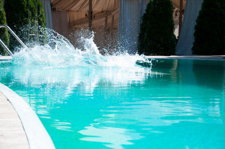 Ripple water of splashes in swimming pool. Splashing water. Turquoise clear pool water. Idyllic summer vacation. Rippled poolside surface. Pool water surface with splash.の写真素材