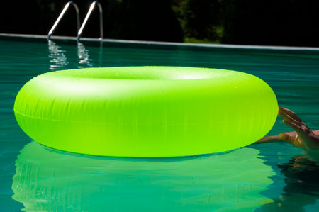 Summer vacation. Relaxing at the pool. Summer resort vacation. Recreation concept. Inflatable ring in swimming pool. Swimming bright ring. Fun in the pool. Inflatable ring at poolside. Refreshing summer.の写真素材