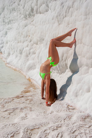 Sporty gymnast in swimsuit. Woman doing handstand. Yoga and fitness. Diet and dieting. Skincare in sunny summer. Fit body skin care. Girl sport swimsuit. Beach vacation summer woman. Spa wellness, laser.の写真素材