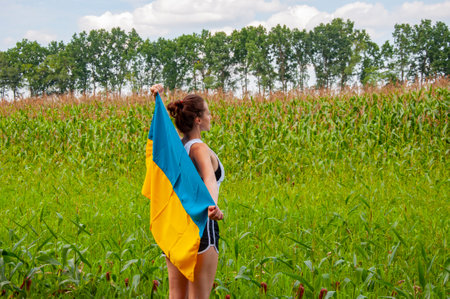 National flag patriotic girl. Independence day. Patriotic symbol. Patriotism. Ukrainian flag memorial day or 24th of August. Girl covered with Ukrainian flag in field. Flag of Ukraine.の写真素材