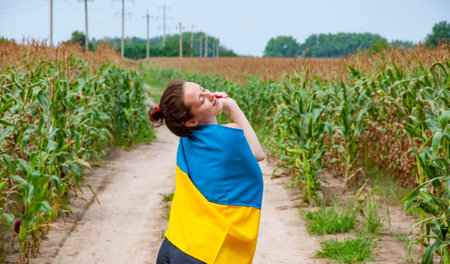 Independence day. Woman countryside road. Girl with Ukrainian flag in crop agricultural field. Future. Independence day of Ukraine. 24th of August. Ukrainian flag and patriotic woman. Flag Ukraine.の写真素材