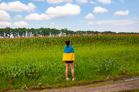 Independence day of Ukraine. 24th of August. Ukrainian flag and woman farmer. Flag Ukraine. Independence day. Woman in the field. Girl with Ukrainian flag in crop field. Confidence in the future.の写真素材