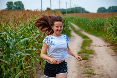 Tradition Ukraine. Vyshyvanka Day. Woman Ukrainian embroidery Vyshyvanka running in field. Ukrainian girl run in countryside. Ukraine Independence. National Ukrainian embroidery. Cultural continuity.の写真素材