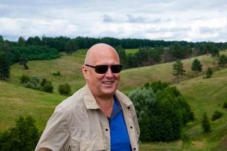 Man at valley landscape peak. Man in autumn style at nature landscape. Travel portrait of man....