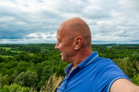 Selfie man portrait. Nature landscape valley selfie. Travel portrait of man. Tourist man on hill. Landscape scenic nature hill. Traveler at mountain wilderness. Adventure at scenic location.の写真素材