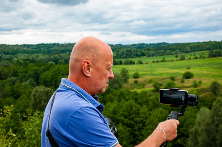 Vlog and video blogging. Landscape photography. Male photographer photographing valley nature...