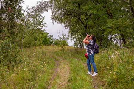 Woman backpack tourist hold binoculars. Observing nature. Woman explore environment. Woman...