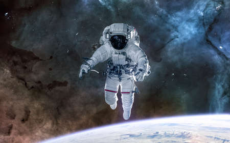 Astronaut in orbit of the Earth. Solar system, nebulae. Science fiction.の写真素材