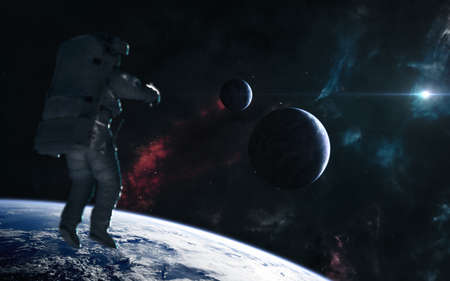 Astronaut on background of planets in rays of blue star. Nebulae of deep space. Science fiction.