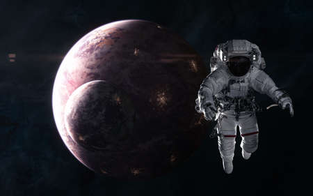 Astronaut on background of inhabited planets in red light. Deep space. Science fiction.の写真素材