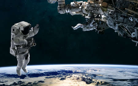 Astronaut and space station orbiting planet Earth. Solar system. Science fiction.