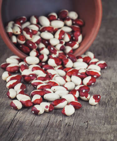 clay bowl with haricot bean on a wooden backgroundの写真素材