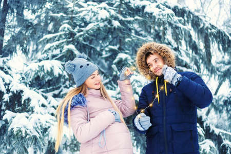 Young pregnant couple in winterの写真素材