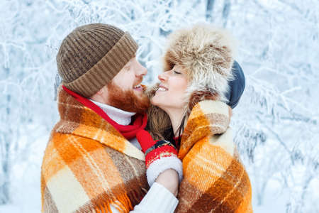 couple hugging outdoors in winterの写真素材