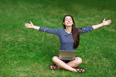 young woman with laptop outdoorsの写真素材