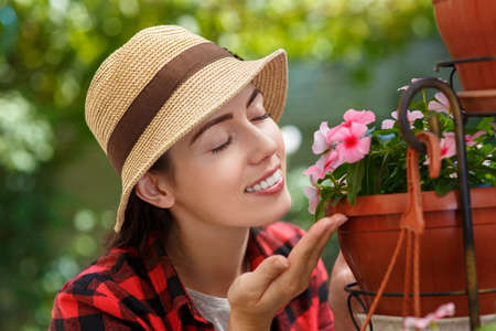 woman gardener smelling flowersの写真素材