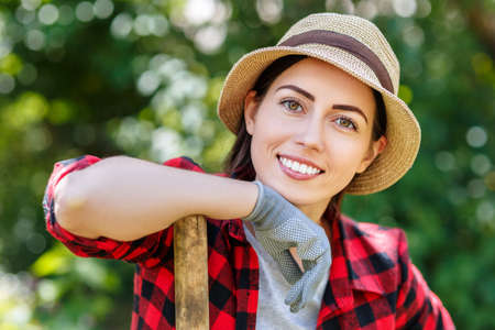 woman gardener holding shovelの写真素材