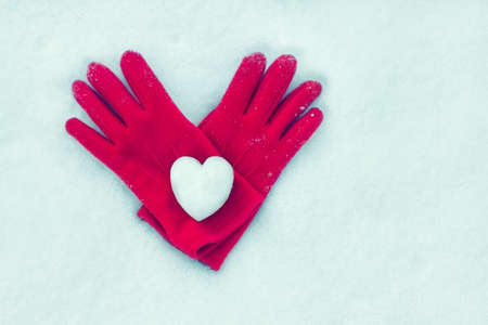 snow heart on red glovesの写真素材