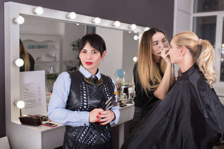 makeup teacher holding brushes