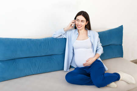 pregnant woman speaking by smartphoneの写真素材