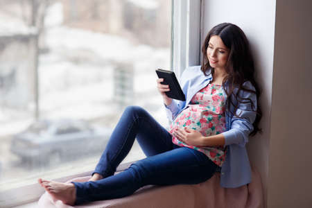 pregnant woman using tablet computer