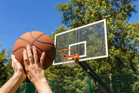 hands throwing basketball ball