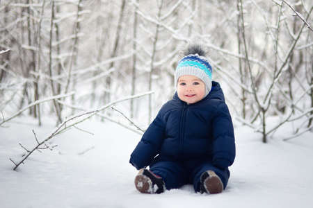 baby boy sitting on snowの写真素材