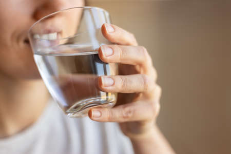 smiling woman with drinking water in glass indoors