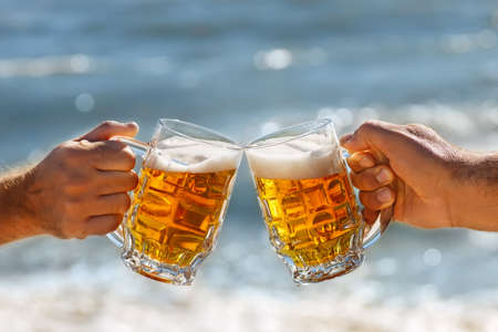 hands with mug of beer making toastの写真素材
