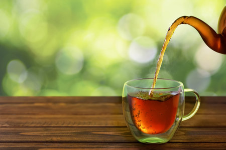 tea pouring from teapot into cupの写真素材