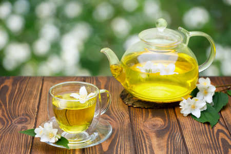 glass cup and teapot of green tea with jasmine flowersの写真素材