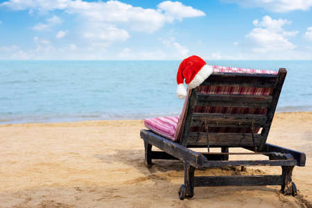 Santa hat on chair lounge on the sea beachの写真素材