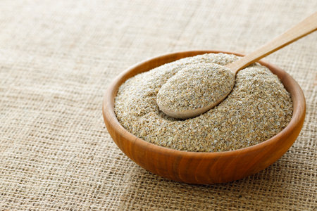 rye bran in bowl and in spoon on table with sackclothの写真素材