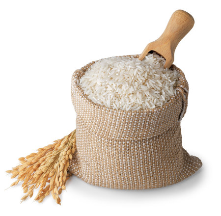 long rice in burlap sack and wooden spoon inserted on top with ears isolated on white backgroundの写真素材