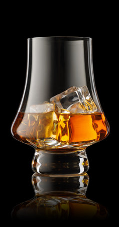 Glass of scotch whiskey and ice isolated on black background with clipping pathの写真素材