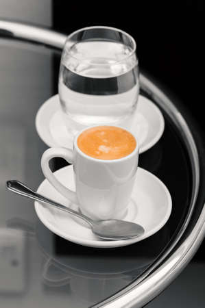 Espresso coffee and glass of water on top table