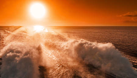 Ferry liner powerful engines lift high spray at the back of the shipの写真素材