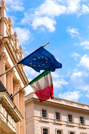 Italian and European Union flags waving from the embassy balcony in London exterior view outdoors...